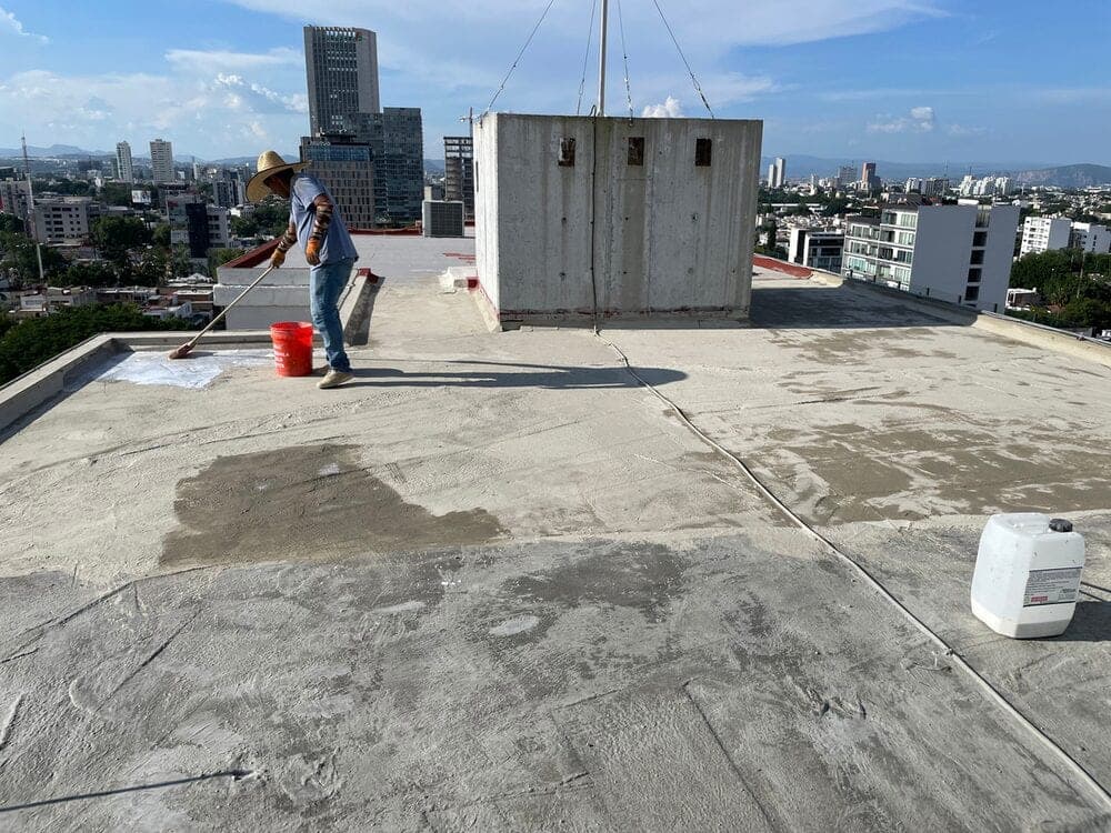 Azotea de un edificio en altura durante la aplicación de PHYCOTECH, con la ciudad al fondo